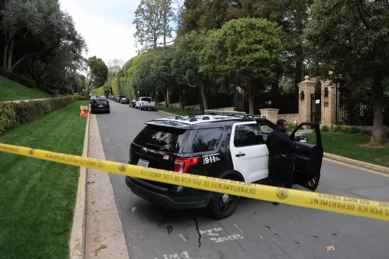 A police car on a road, with caution tape near it. 